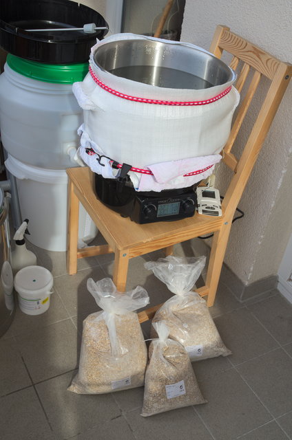 Das Herzstück der &quot;Anlage&quot;, der ProfiCook-Einkocher mit einer alten Frontscheibenabdeckung als Isolation. Zwei Handtücher darunter sollen das Schmelzen der Matte verhindern.  Links blitzt noch der neue 38l Thermoport hervor, der fürs Läutern zum Einsatz kommen sollte