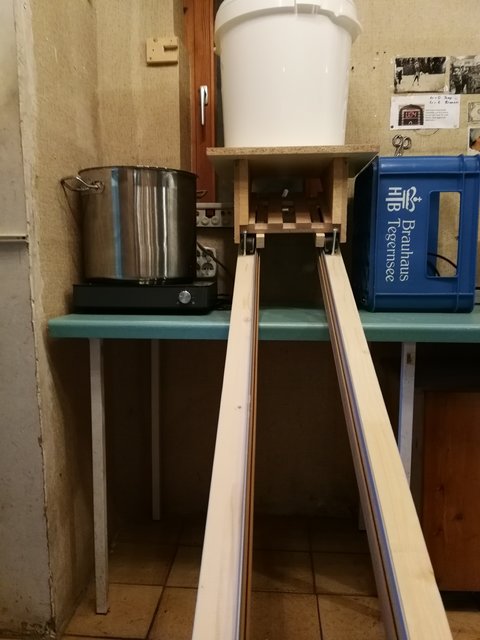 Zum Abfüllen steht der Bottich auf dem blauen Bierkasten.