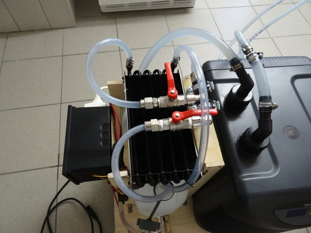 Man sieht die Vorkühlmöglichkeit:<br />Wenn ich Bier braue, so kühle ich dieses nach dem Hopfenkochen auf ca. 60° herunter. Anschliessend wird die warme Würze in den Keller getragen und in den den Gärbehälter geschüttet. <br />Dies mache ich so, weil ich erstens weniger lange warten muss, bis die Würze kühl wird und zweitens, weil ich mir so erhoffe, dass durch die Wärme evtl. noch ein paar Bakterien abgetötet werden. <br /><br />Nach dem einfüllen starte ich die Kühlalage. Aber zuerst ohne Durchlaufkühler. Das heisst, das kalte Wasser wird im Ausgleichsbehälter angesaugt, durch den Durchlaufkühler gedrückt (dieser ist aber noch nicht eingeschaltet), fliest in die Kühlspirale und nimmt die Wärme der Würze auf. Anschliessend läuft das Wasser aber nicht direkt in den Ausgleichsbehälter, sondern fliesst durch den Radiator (unter dem Radiator sind Lüfter eingebaut). Danach läuft es in den Ausgleichsbehälter. <br /><br />Diesen Prozess lasse ich so lange laufen, bis die Würze ca. 30° erreicht hat. Dann werden die Höne beim Radiator umgestellt, damit das Wasser nach der Kühlspirale ohne Umwege in den Ausgleichsbehälter läuft.